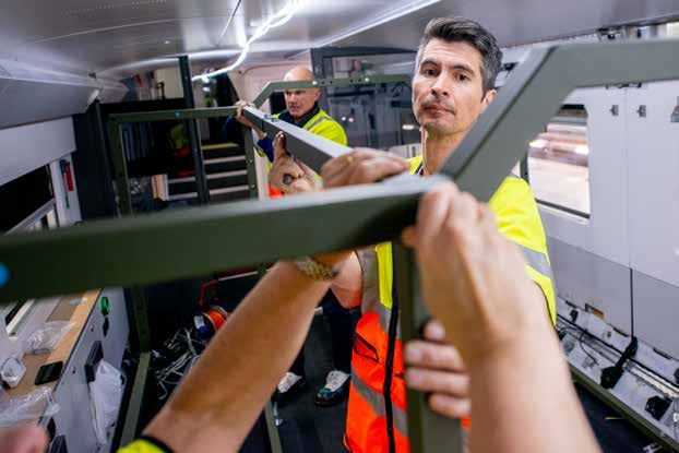 Industriell konstruktionsverkstad med tekniska ritningar på ett arbetsbord.